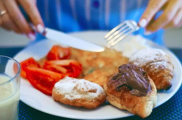 Woman breakfast with omelette croissant, close up