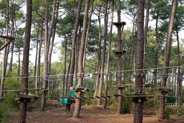 ropes course in treetop adventure park passing hanging rope obstacle