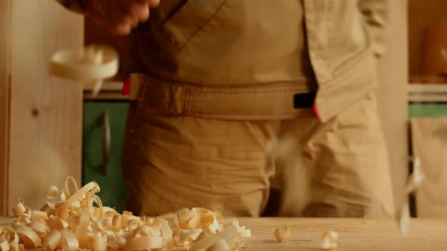 Joiner with bristle brush throw about beautiful heap of wood sawdust in the carpentry