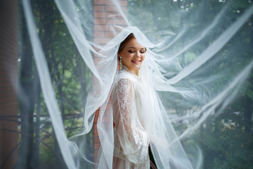 beautiful bride in a wedding morning in a bathrobe and veil
