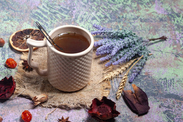 Red Hot Hibiscus tea in a glass mug on a wooden table among rose petals and dry tea custard with carcade