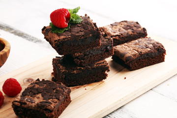 chocolate brownie cake dessert with raspberries and spices on a wooden background.