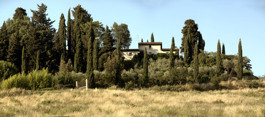 Fototapeta na wymiar Tuscan Villa upon hilltop surrounded with cypresses