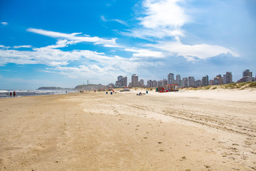 Obraz premium Mar e areia e o céu azul com nuvens na Praia Grande, cidade de Torres, estado do Rio Grande do Sul, Brasil