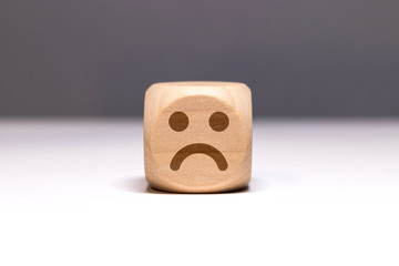 Pictogramme smiley triste sur cube en bois