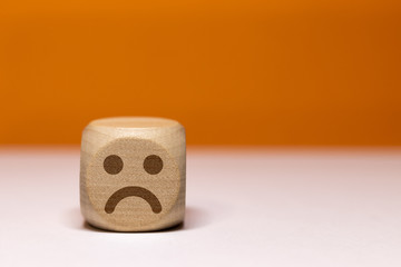 Pictogramme smiley triPictogramme smiley triste sur cube en boisste sur cube en bois