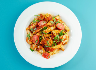 Penne pasta with a rich tomato sauce and slices of British pork sausage topped with Cheddar cheese