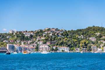 Fototapeta na wymiar Beautiful builings and mansions at the costline and hillslope with green forest in summer, at Bosphorus Strait in Istanbul,Turkey. View from a Cruise Ship.
