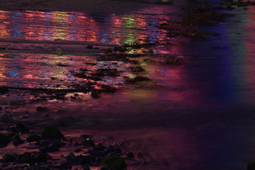 Reflections on the beach of the Christmas Lights at Mousehole Cornwall