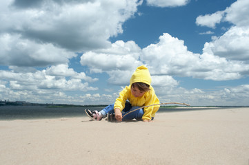 Fototapeta na wymiar A child plays outdoors in a sand dune