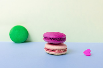Beige and red, green macaroons with hearts are on a light background. Greeting card Valentine's day.  Copy space.