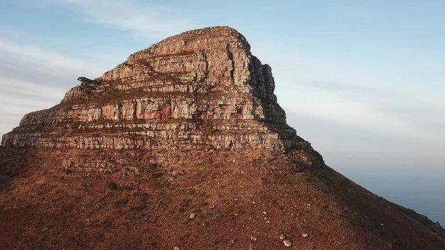 4K high quality aerial sunny morning footage of spectacular scenic Lion's Head Mountain, rocky hills with hiking trails, Atlantic Ocean coast panorama in Western Cape, Cape Town, South Africa