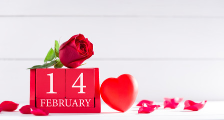 Valentine's Day concept. February 14 letter on wooden calendar and roses on desk