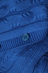 Seamless knitted fabric with pigtails. Knitted sweater with buttons. Knitted background. Classic Blue color 2020