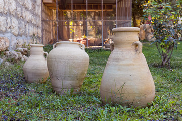 Vintage jugs stand on the grass in the territory of the Greek Monastery - Shepherds Field in Bayt...