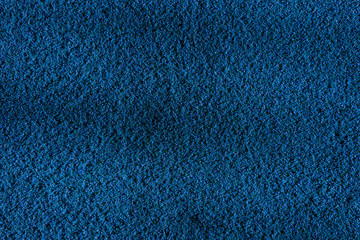 Distressed overlay texture of cracked concrete, stone or asphalt. Grunge blue background.  Small grains of sand as a wallpaper