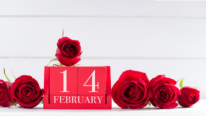 February 14, Valentine's Day concept. February 14 letter on wooden calendar and roses on desk