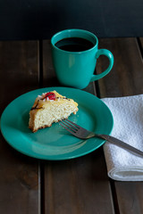 front view of portion of chocolate-dipped Easter thread with cherries and custard and a cup of coffee