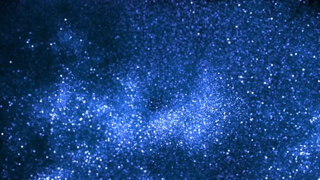 Super slow motion of glittering blue particles on black background. Shallow depth of focus. Filmed on high speed cinema camera, 1000 fps.