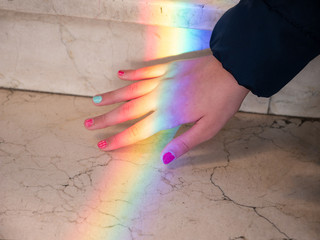 hand of a girl with rainbow light