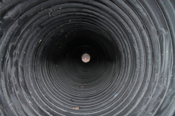 Fototapeta na wymiar Black pipe for draining water. Passage through the pipe