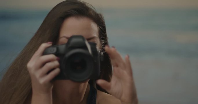 Portrait of a young woman with a photo camera taking a picture