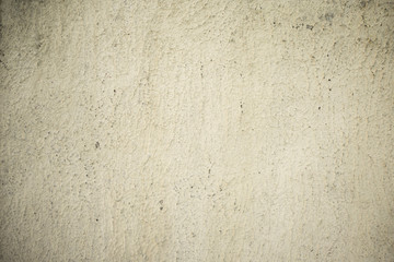 The texture of the concrete wall covered with whitewash with traces of aging.
