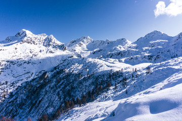 The snowy mountains, the nature and the landscape of the Valtellina after the first snowfall of the season in the Alps, near the town of Tartano, Italy - November 2019.