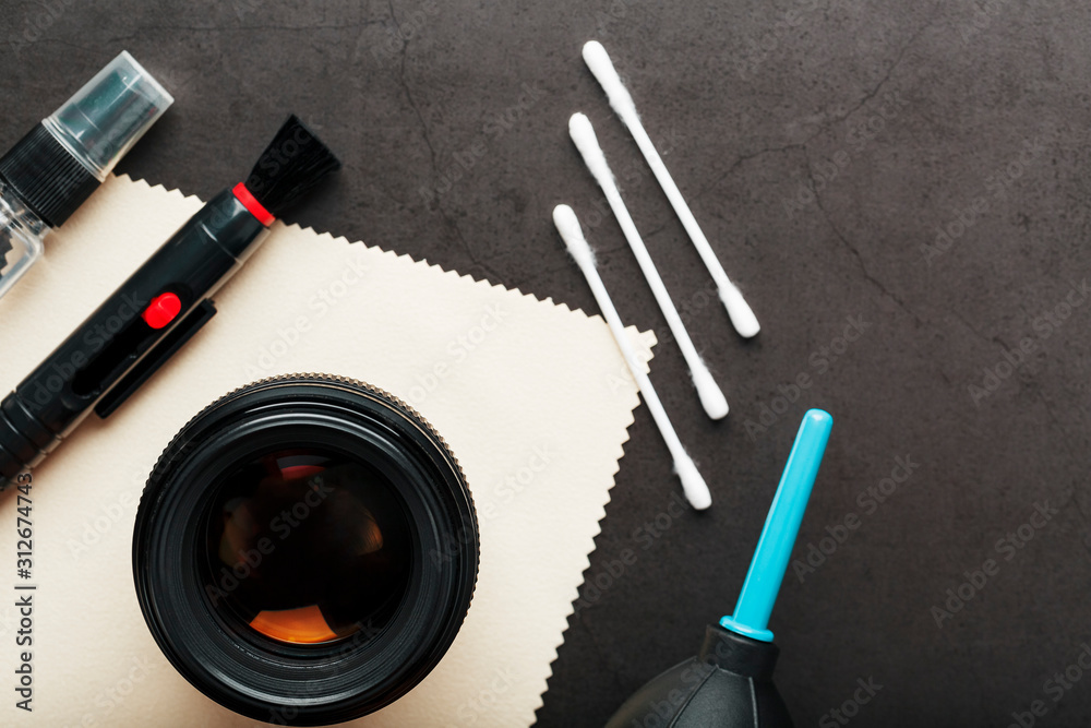 Poster tools for cleaning the camera with lenses on a dark textured background.