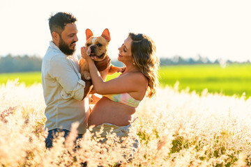 Pregnancy, motherhood, people and expectation concept, couple holding french bulldog.