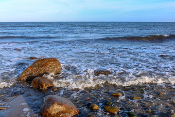 Fototapeta na wymiar Waves break on the stones on the Baltic Sea beaches near Hohwacht, Germany