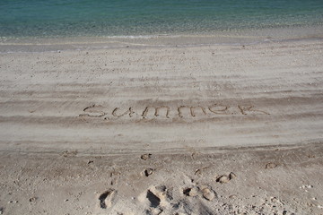 Fototapeta na wymiar Summer text written on white sand beach near sea