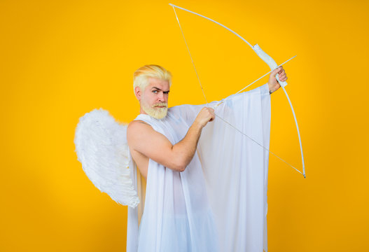 Cupid shoot with bow. Cupid angel with bow and arrows. Symbol of love. Happy Valentines Day. Smiling man in angel costume. Valentines day angel. Cupid. Amour. Cupid with bow. God of love. February 14.