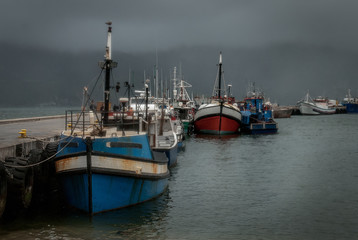 Wet and windswept fishing fleet in port