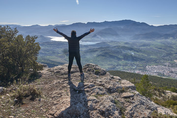 woman loving nature and sun in the mountain open arms