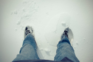 Legs and feet seen from above, walking in the snow
