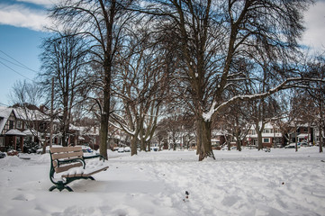 A park bench covered in snow