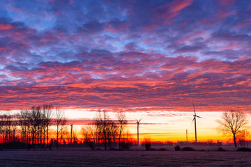sunrise with windmills and colourfull clouds