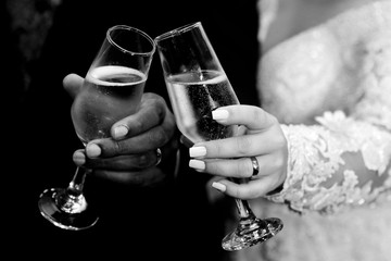 Hands with wedding rings holding champagne glasses