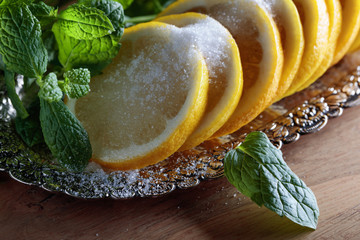 Lemon slices with sugar and mint leaves.