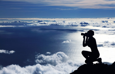 Fototapeta na wymiar Young girl trekking and taking photos on Pico volcano (2351m) on Pico Island, Azores, Portugal, Europe