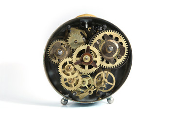 Back side of old mechanical table clock isolated on white background. Clockwork details, pinions and wheels..