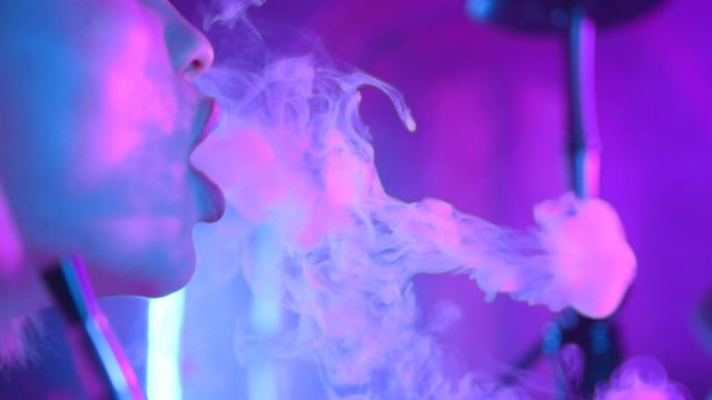 Face young girl smoke hookah at the bar friendship communicate emotion shisha smoker lounge female vape beautiful attractive company relax slow motion
