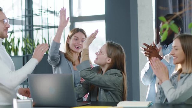 Happy multi-ethnic co-workers gathered together working discuss current issues common tasks african team leader talk with colleague business workplace skilled technology strategy slow motion