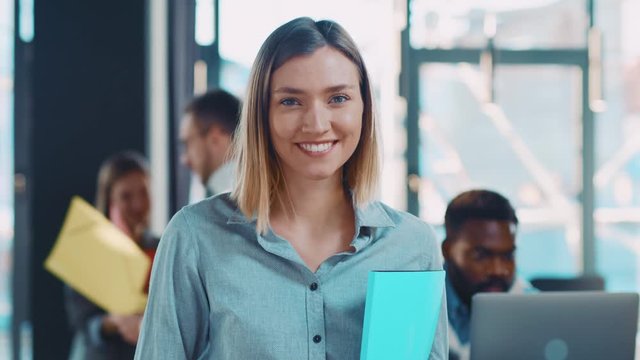 Smiling happy businesswoman looking at camera confident lady boss in office workspace attractive ambition friendly independent startup job portrait close up slow motion
