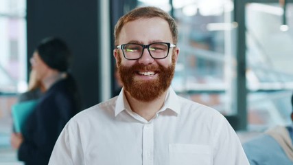 Portrait young man team leader with smiling face posing in office confident business executive ceo looking at camera startup founder training work startup success successful beard close up slow motion