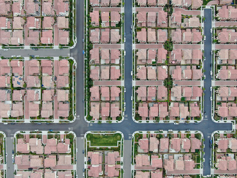 Aerial top view of urban sprawl. Suburban packed homes neighborhood with road. Vast subdivision in Irvine, California, USA
