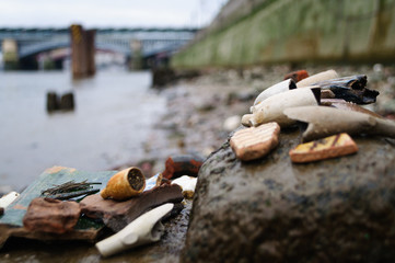 Mudlarking on the River Thames in London, UK : Mudlark findings on the shore
