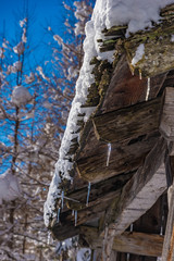 roof of a wooden barn with snow and icicles