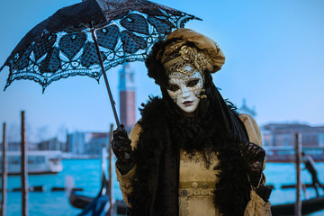 Fototapeta na wymiar femme costum�e masqu�e avec ombrelle venise
